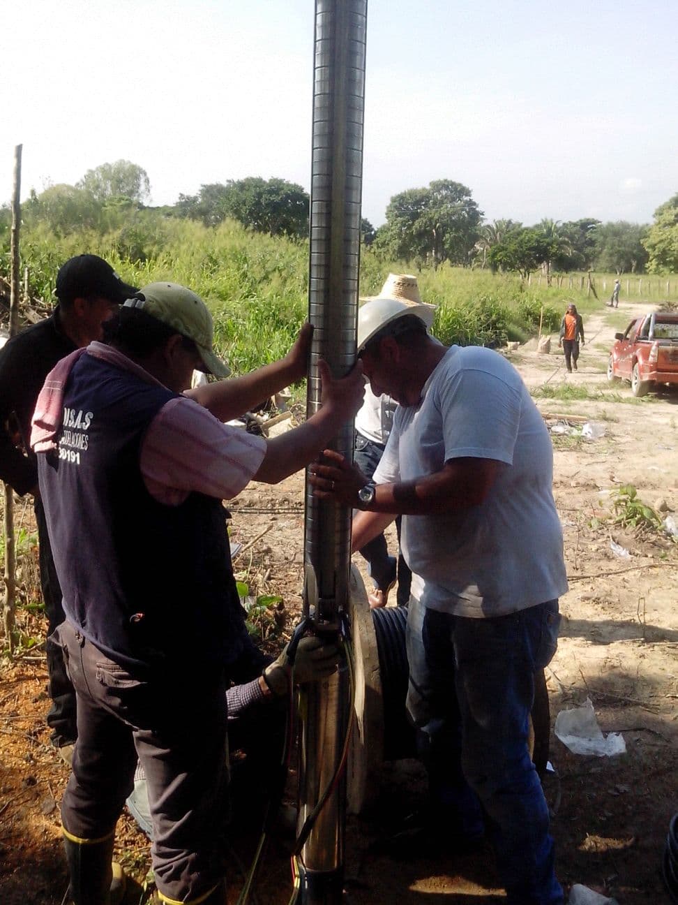Technician inspecting a submersible solar pump installation